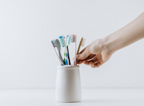 Hand reaches for toothbrush