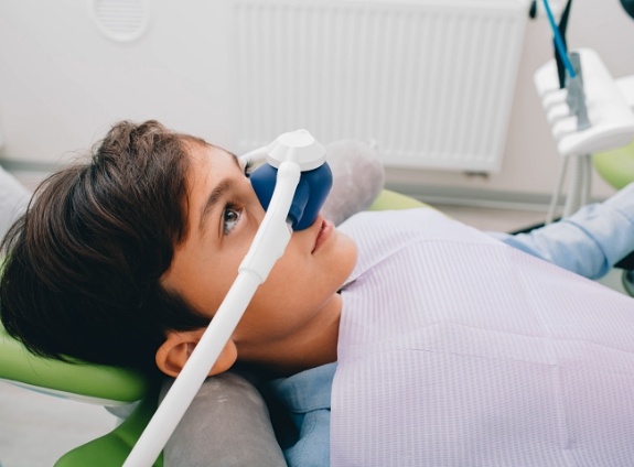 Young boy in dental chair with mask on his nose for nitrous oxide sedation dentistry