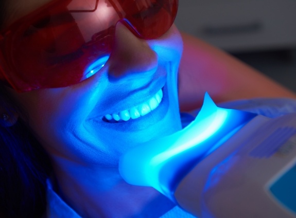 Woman getting her teeth whitened in dental chair