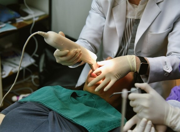 Dentist taking digital dental impressions of a patients teeth