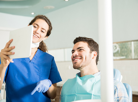 Dentist showing a patient an image on tablet