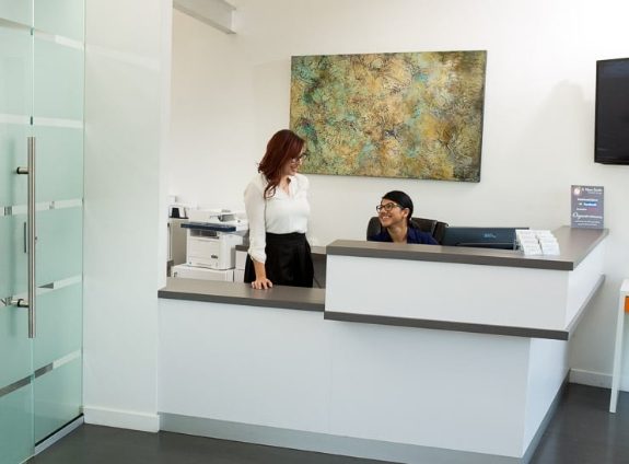 Two Santa Clarita dental team members at front desk