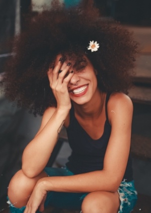 Smiling young woman resting her head in her hand