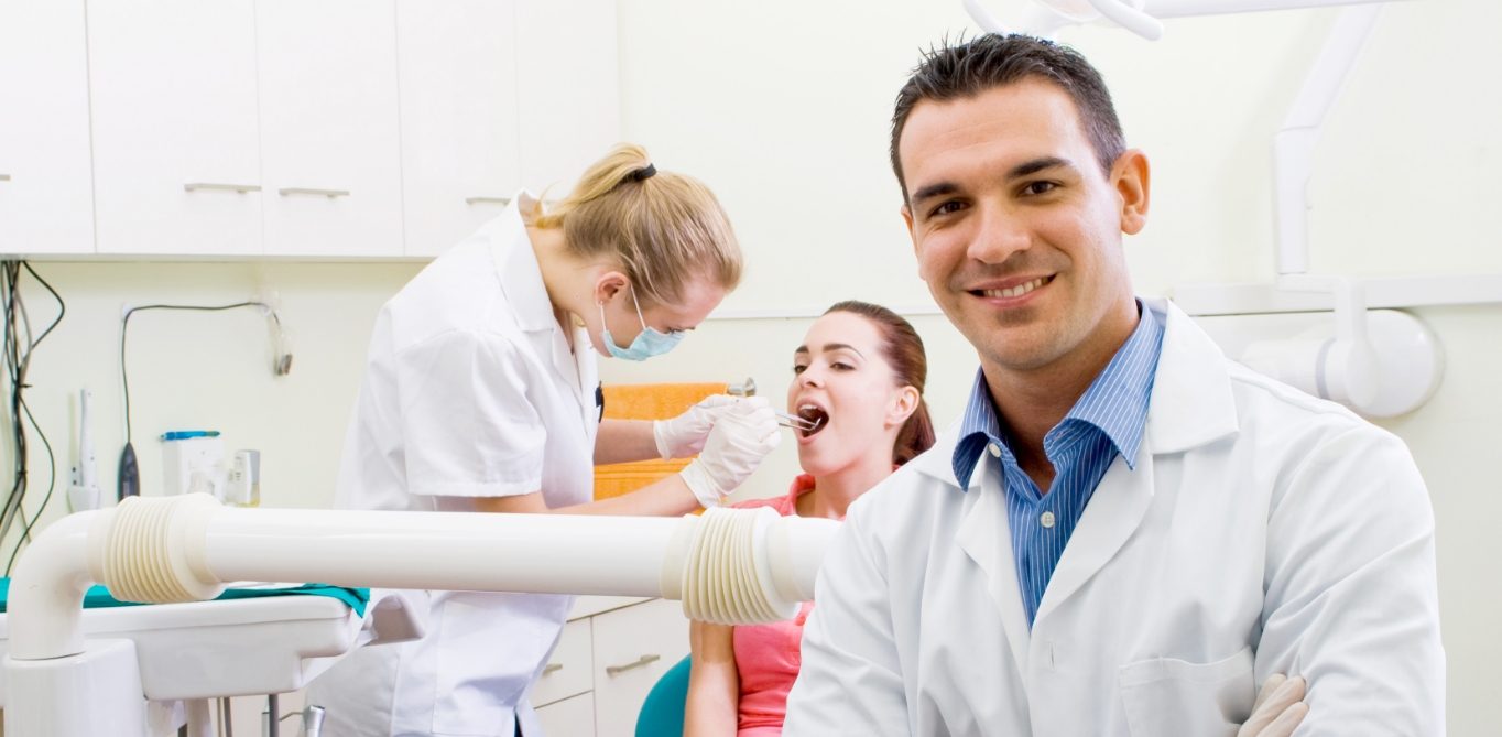 Santa Clarita endodontist smiling while dental team member examines patient
