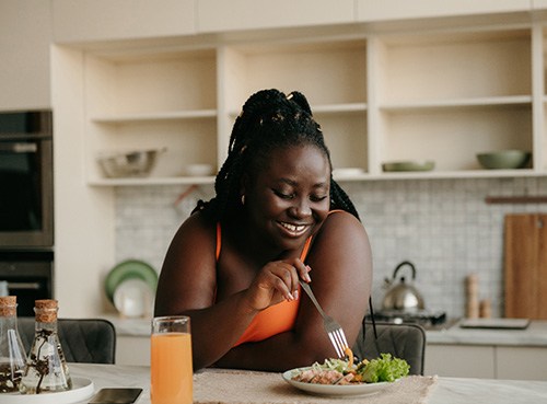 Woman smiling while eating lunch at home