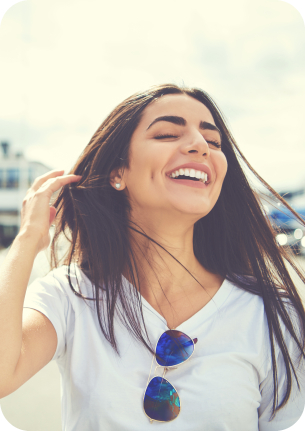 Young woman smiling outdoors on sunny day