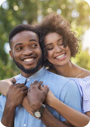 Young man and woman hugging outdoors